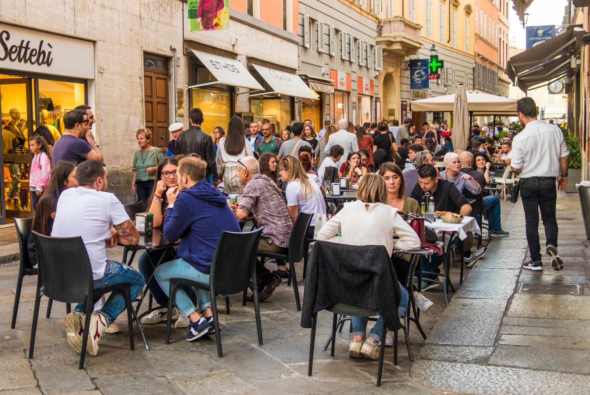 People sitting outside at a restaurant in Parma, Italy