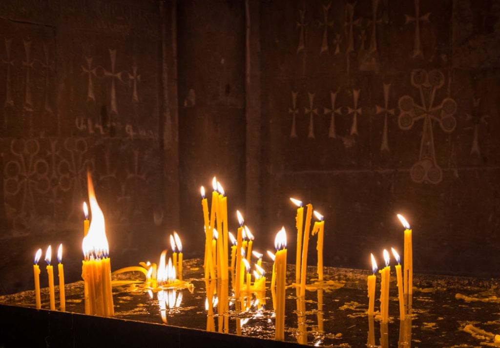 Candles lit on an altar inside a monastery in Armenia.