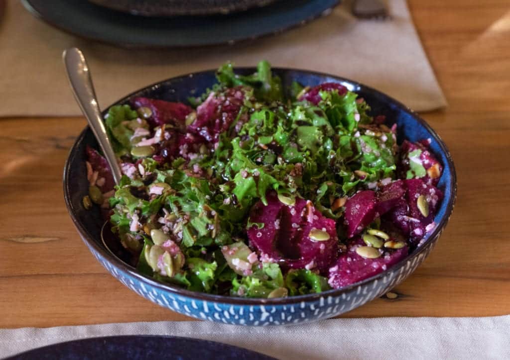 A salad with purple beets and lots of greens.