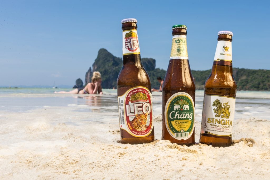 Three Thai beers -- Leo, Chang, and Singha -- standing in the sand on Koh Phi Phi.