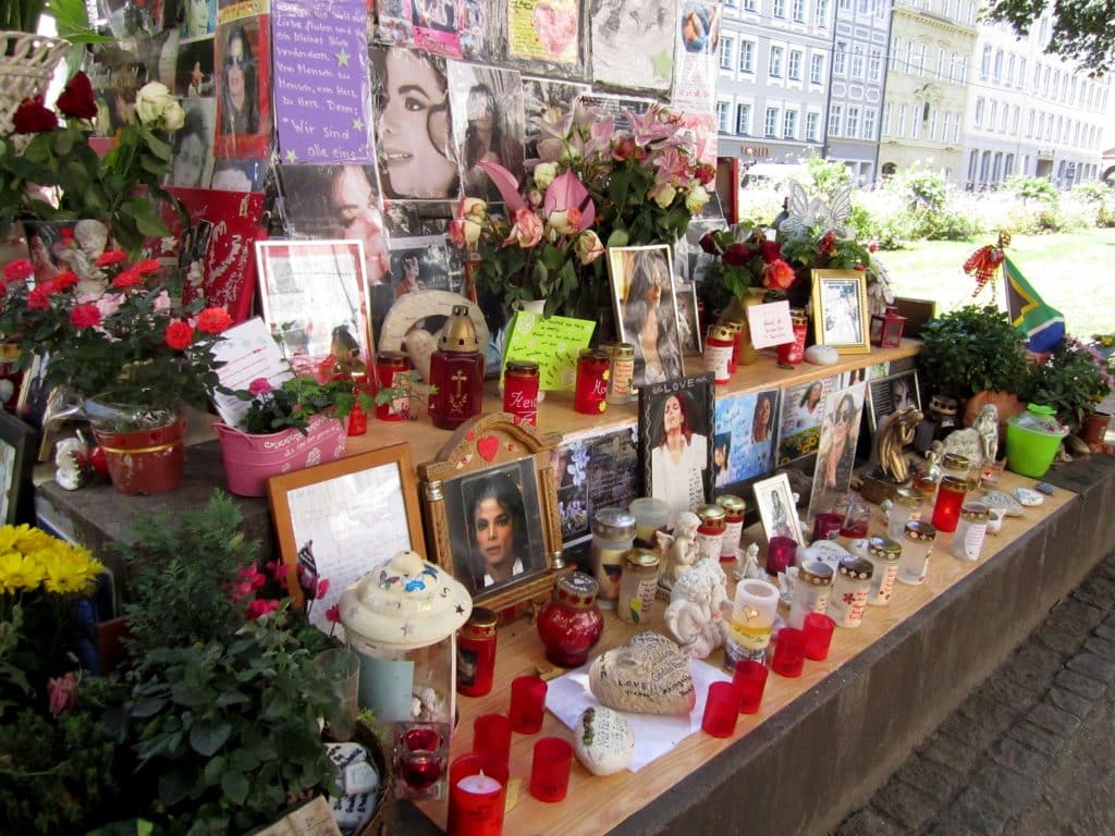 A memorial covered with photos of Michael Jackson, flowers, and candles