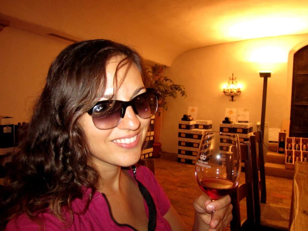 Kate in sunglasses holding up a glass of wine