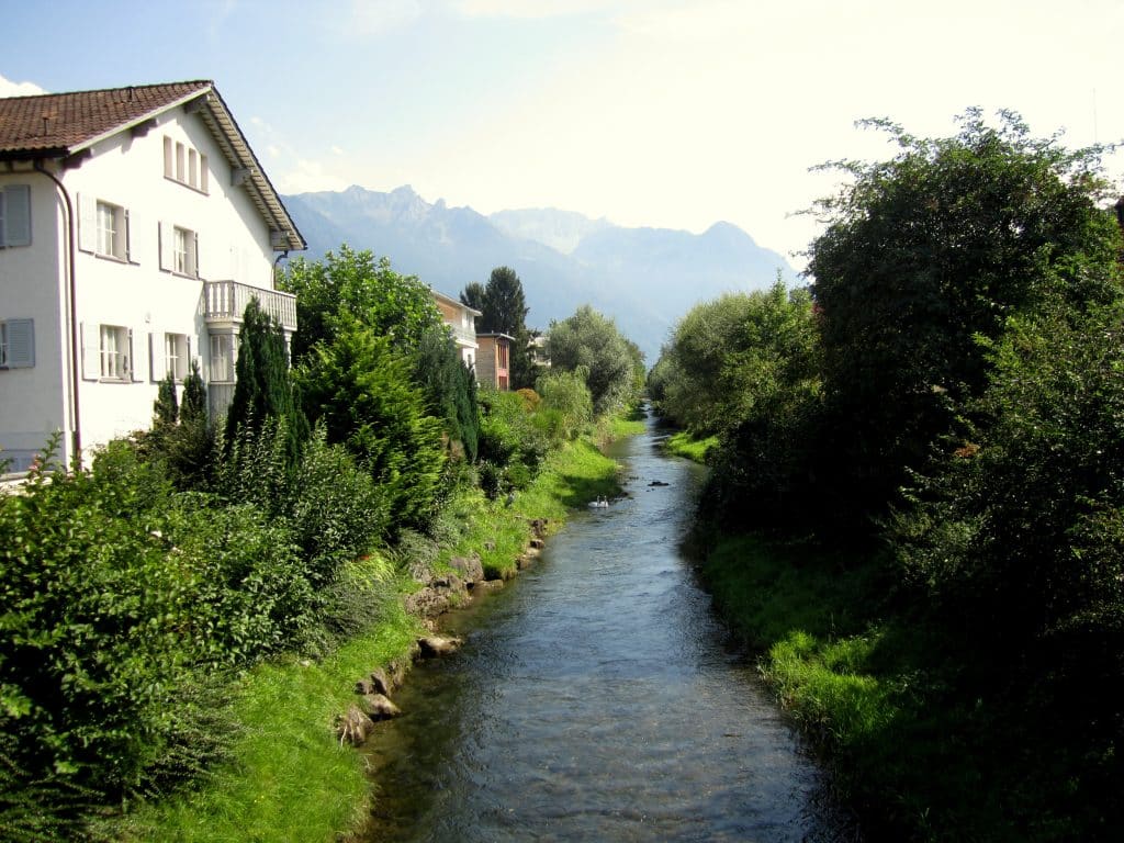 A small river running alongside white houses.
