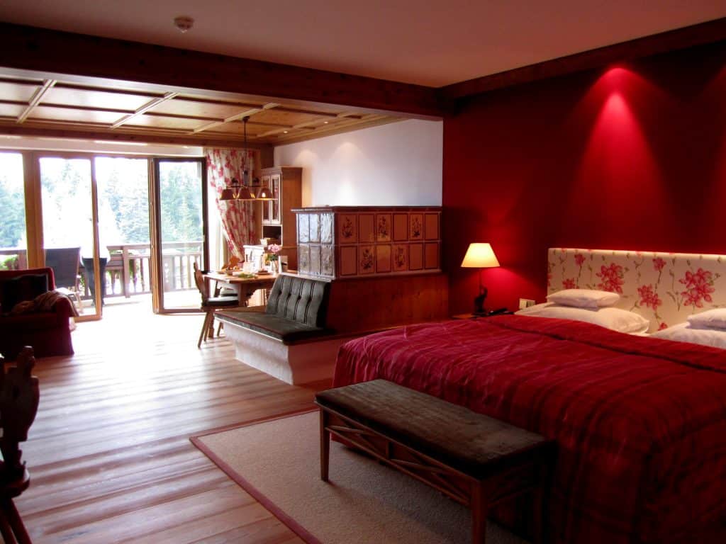 A suite with a bed with a bright red bedspread