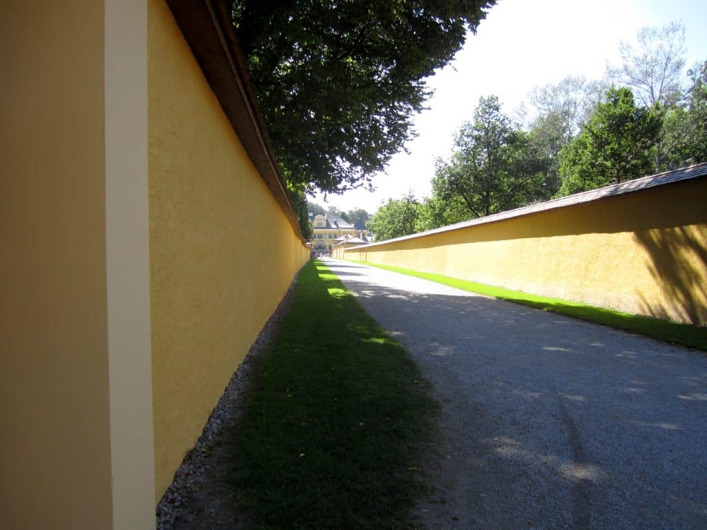 A street edged by two yellow walls.