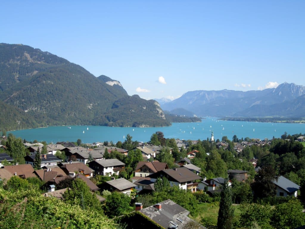 An intensely blue lake surrounded by mountains and small Austrian villages.