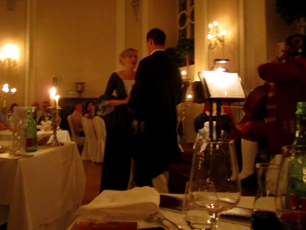 A woman and man singing opera in 18th century clothes.