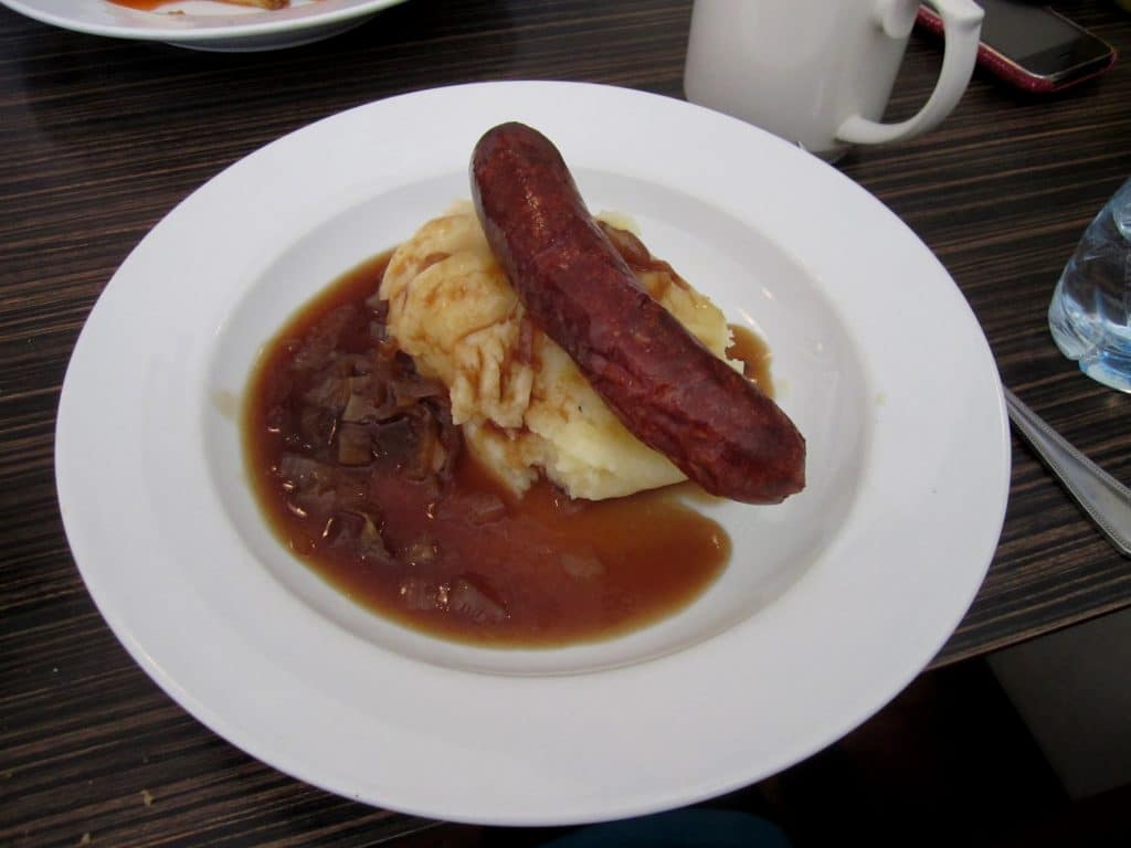 Sausage and mashed potatoes on a plate.