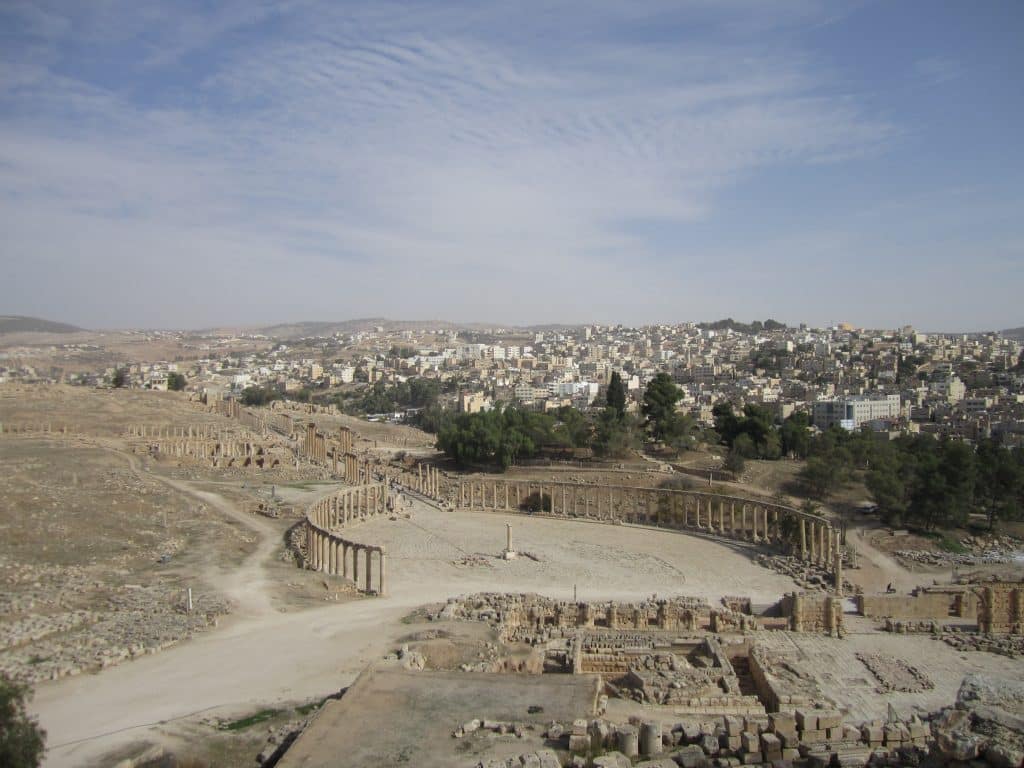 Ruins in the middle of a desert, columns forming a round colonnade.