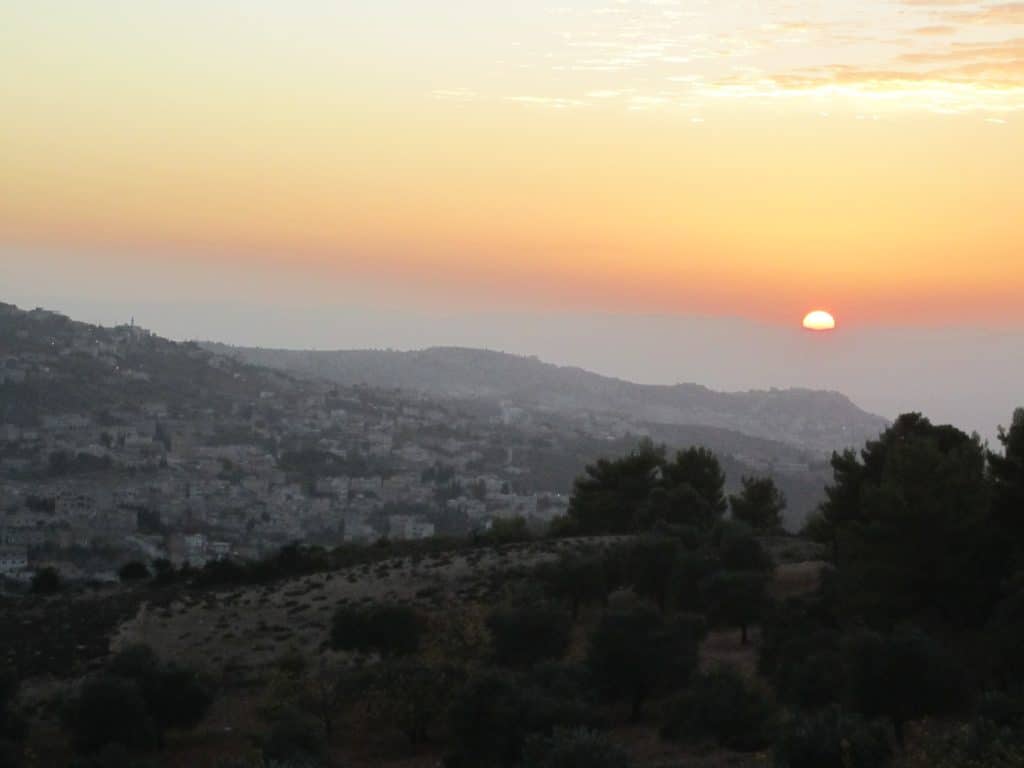 A pink and purple sunset over hills in Jordan