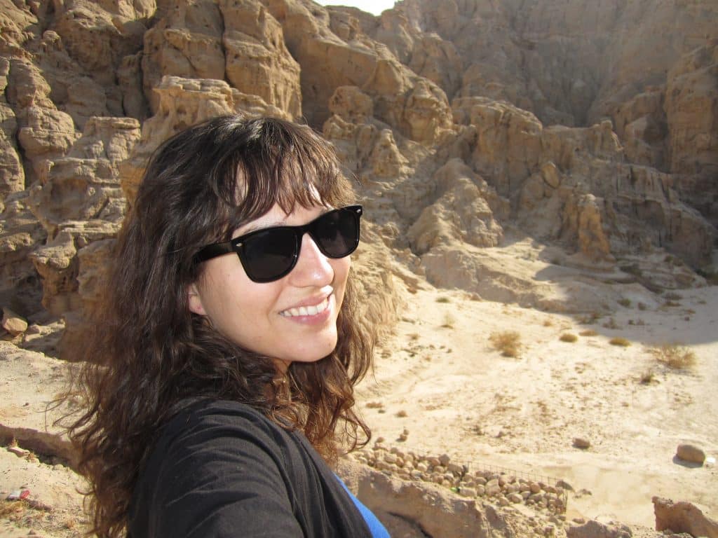 Kate with sunglasses on taking a selfie at a canyon in Jordan