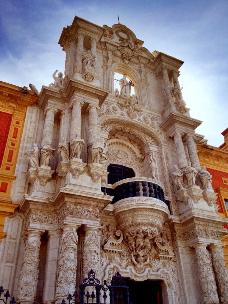 Beautiful Sevilla building with columns and statues.