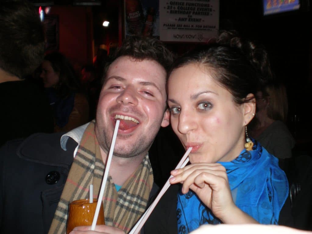 Kate and Josh drinking a scorpion bowl through straws and smiling big