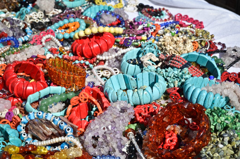 Plastic bracelets for sale, mostly red and turquoise, on a table in New York.