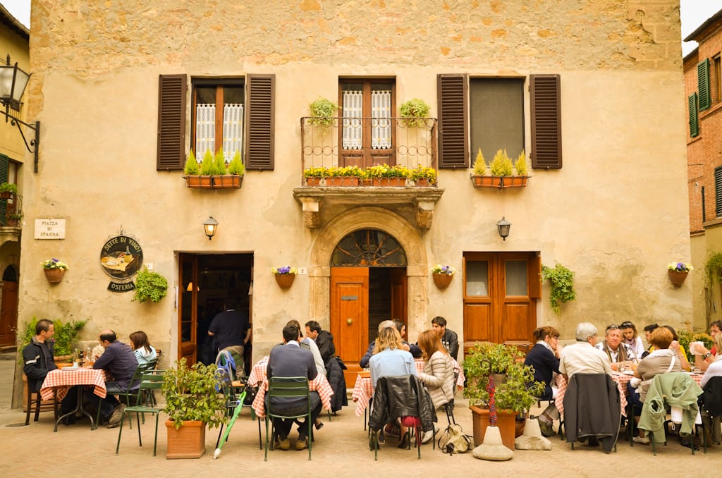 People sitting at an outdoor restaurant in Pienza, Italy.