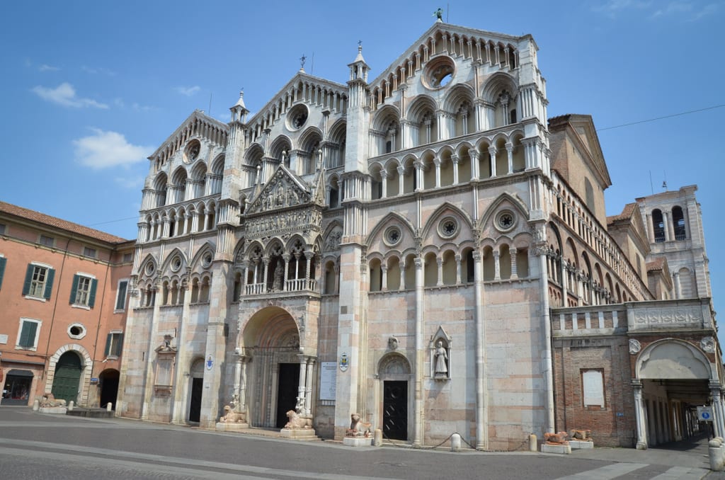 A big white and pink church in the middle of the main square in Ferrara, Italy.