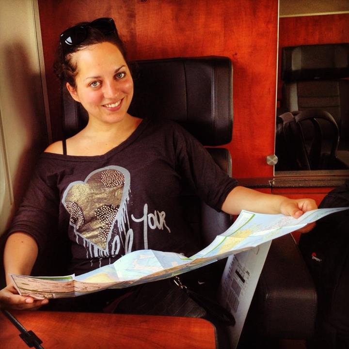Kate holds a map while sitting on a train.