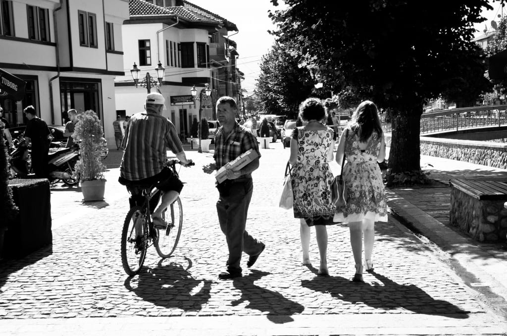 A black and white shot of people walking down the street in Prizren, Kosovo