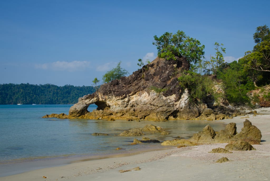 A beach with bright blue water in Koh Phayam, Thailand.