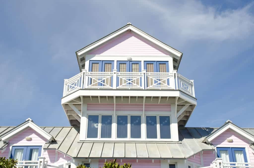 A pink building with purple trim and white balconies in Seaside, Florida.