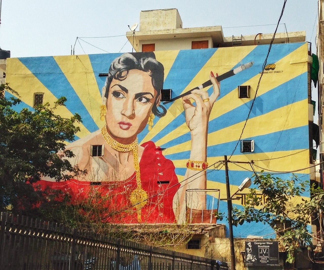 A mural in Delhi featuring a woman in a red dress holding a long cigarette holder.