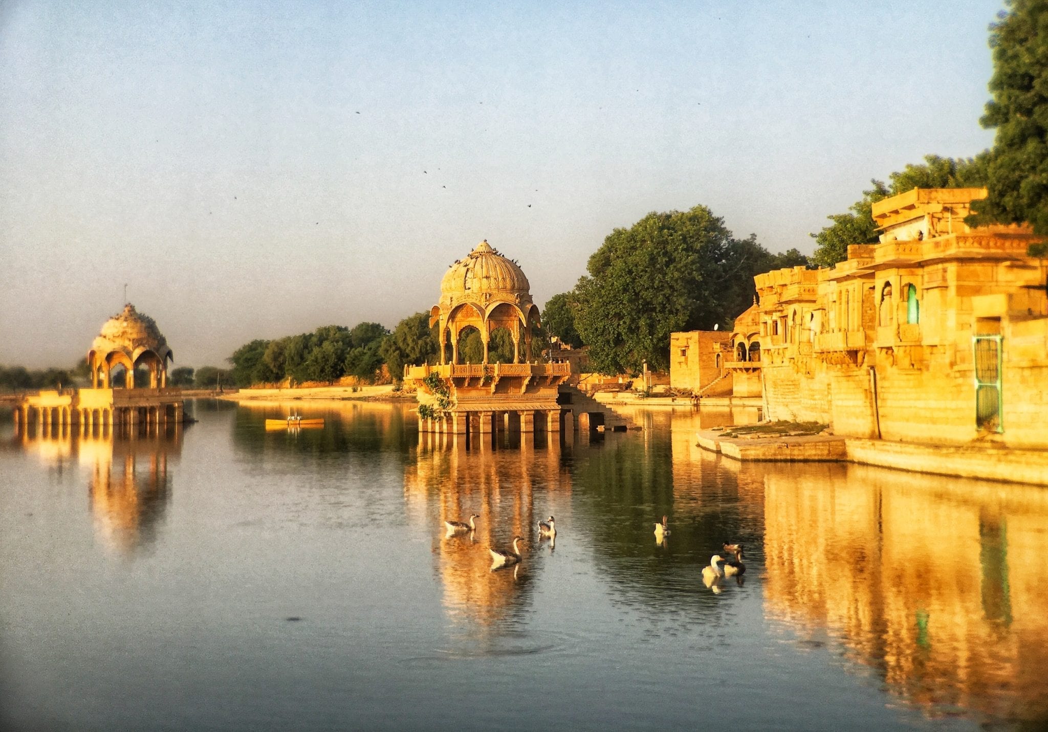 The golden buildings of Jaisalmer, Rajasthan, India, perched on the blue lake at dusk.