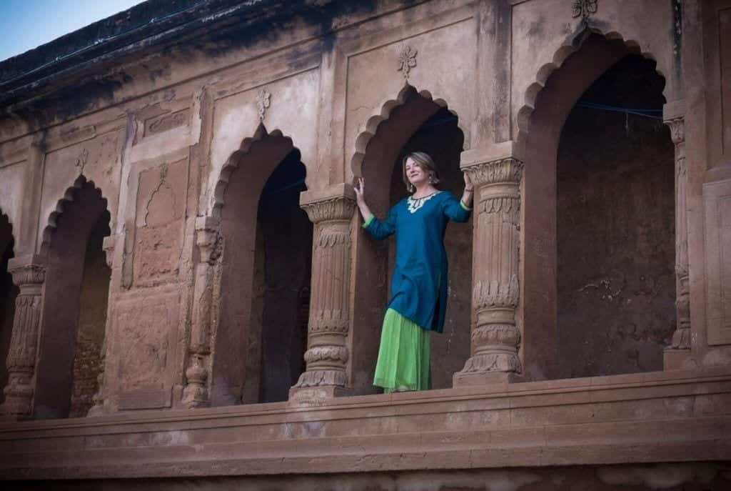 Mariellen Ward in a navy top and bright green skirt in a temple opening in Lucknow, India.