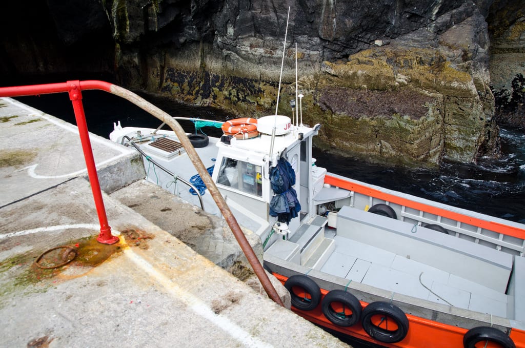 The red boat pulled up to the edge of Skellig Michael, where there is a concrete staircase leading down to the water.