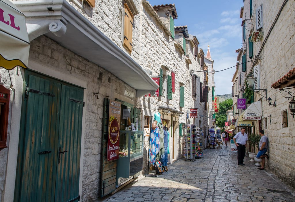 A small cobblestoned street edged with souvenir shops in Trogir, Croatia