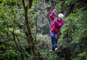 Kate Ziplining in a bright pink sweatshirt and black pants in Monteverde, Costa Rica