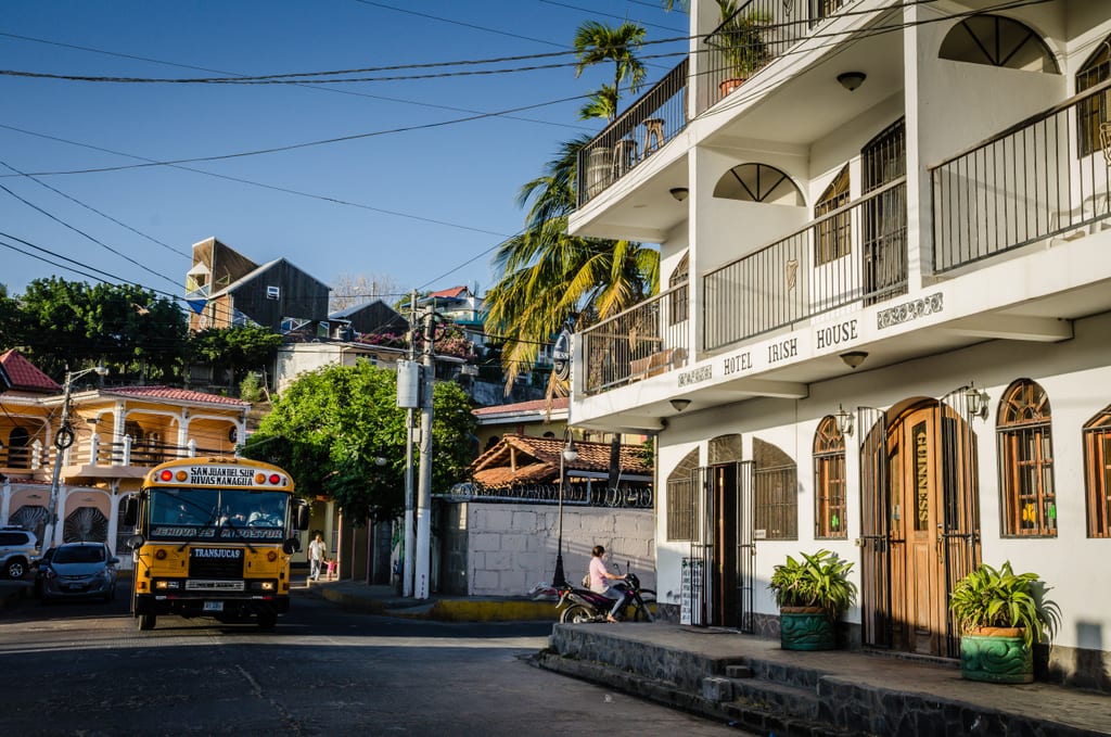 A bus and a white wooden hotel in San Juan Del Sur.