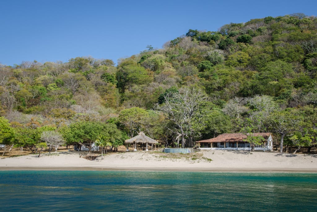 A beach near San Juan Del Sur, with still green water.