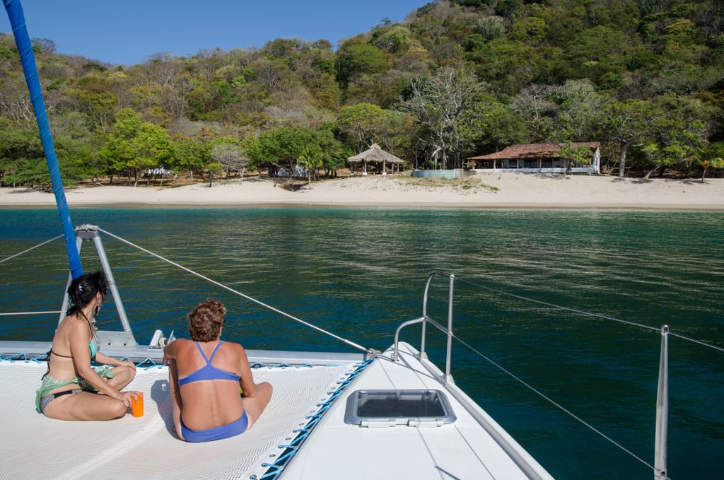 Two women on the front of a white boat overlooking beaches in Nicaragua.