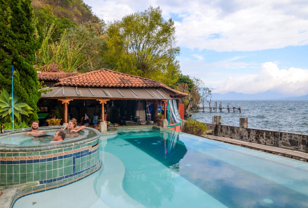 People in an infinity pool overlooking the lake.