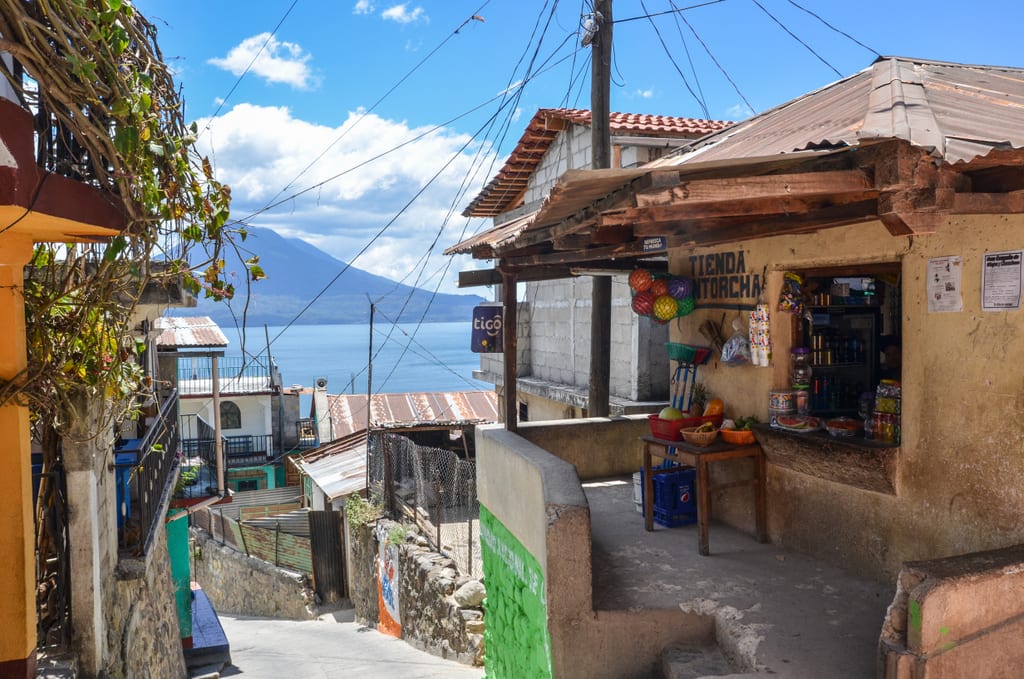 A small shop with stuff for sale on a steep street