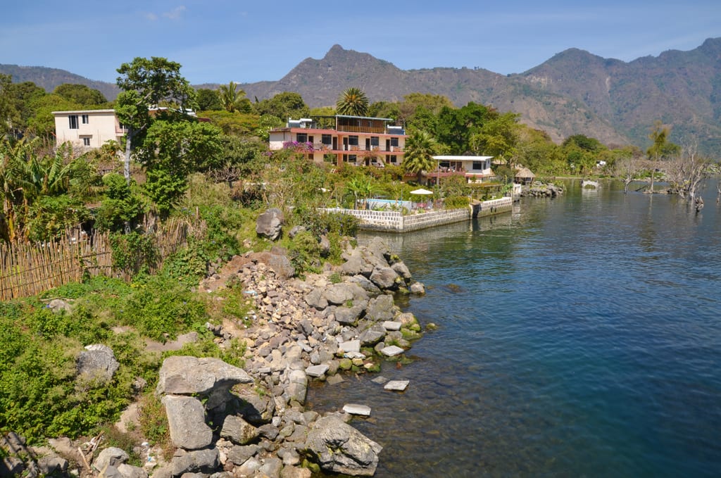 A village perched on the edge of a bright blue lake.