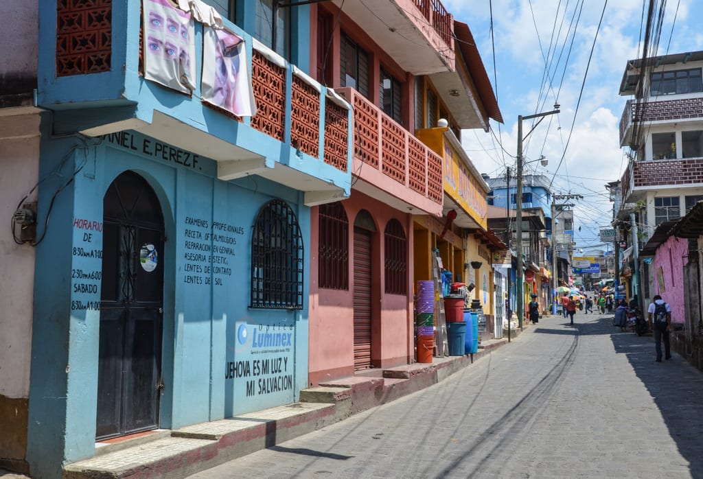 A street covered with blue, red, orange, and yellow buildings.