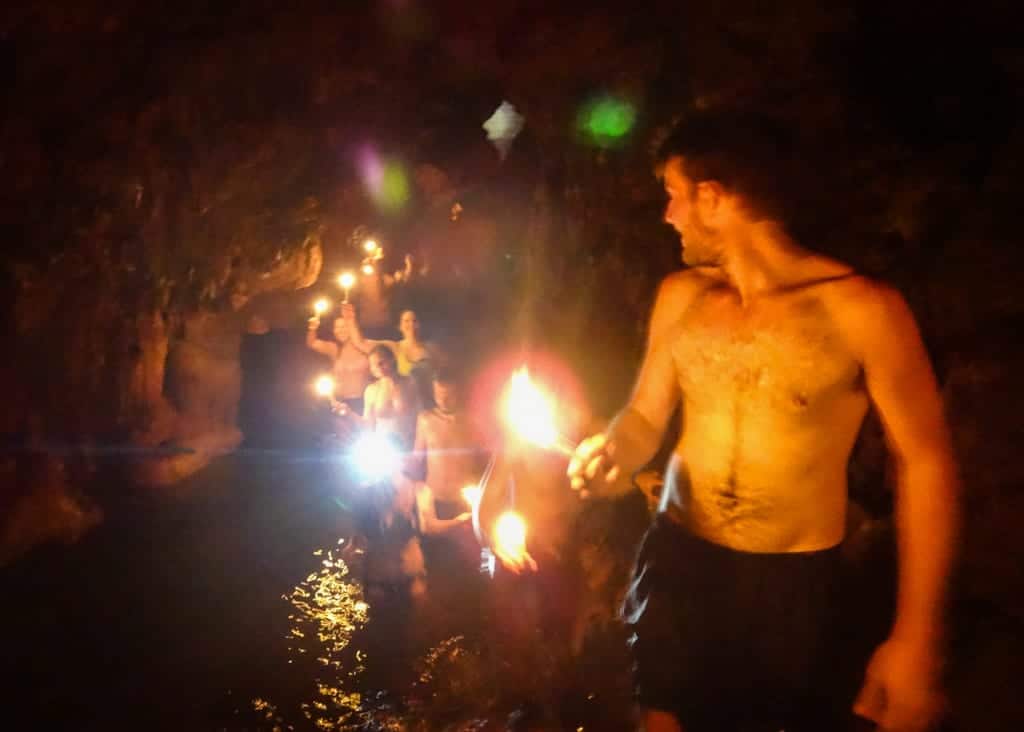 People walking through the Semuc Champey Caves, holding candles.