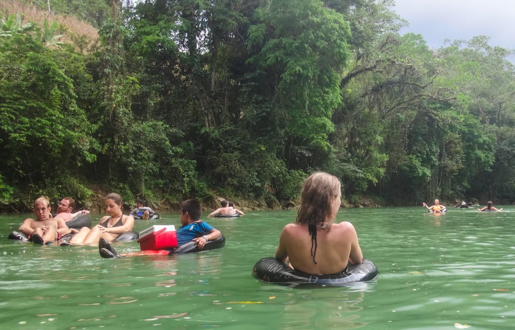 People floating down the Semuc Champey river in tubes. You see one little Guatemalan boy holding a cooler.