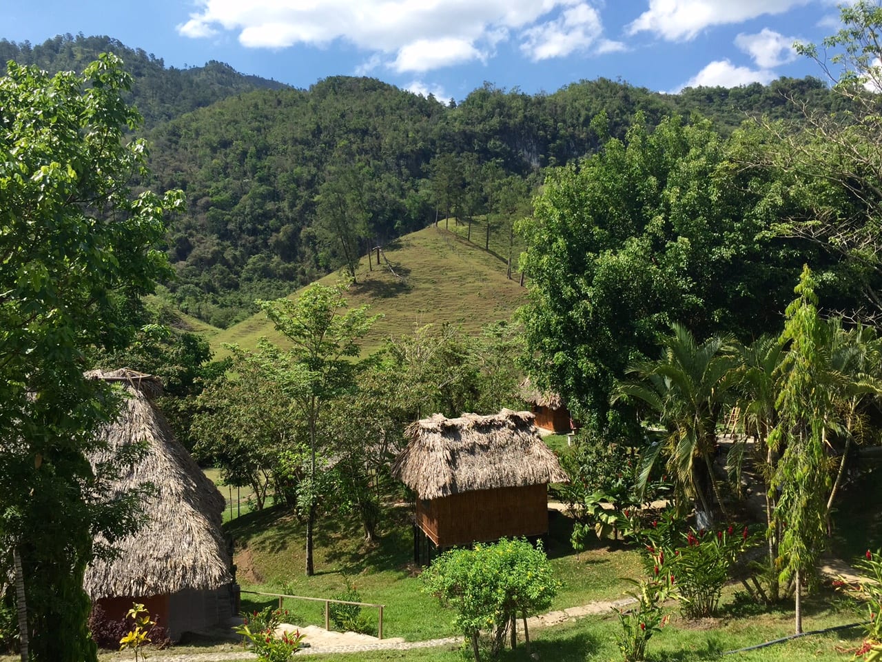 El Retiro Lodge in Lanquin Guatemala: Thatched roof houses set amongst the hills.