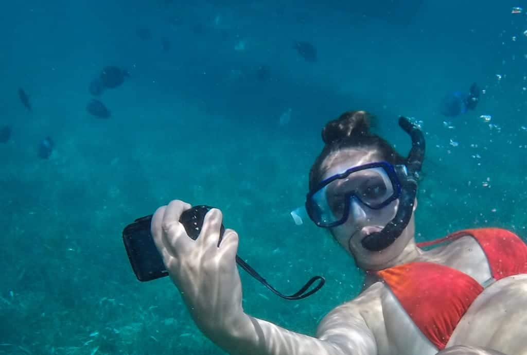 Kate taking a selfie underwater as she swims with sharks