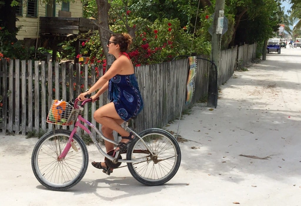 Kate rides a bike down a sandy road in Caye Caulker, Belize.