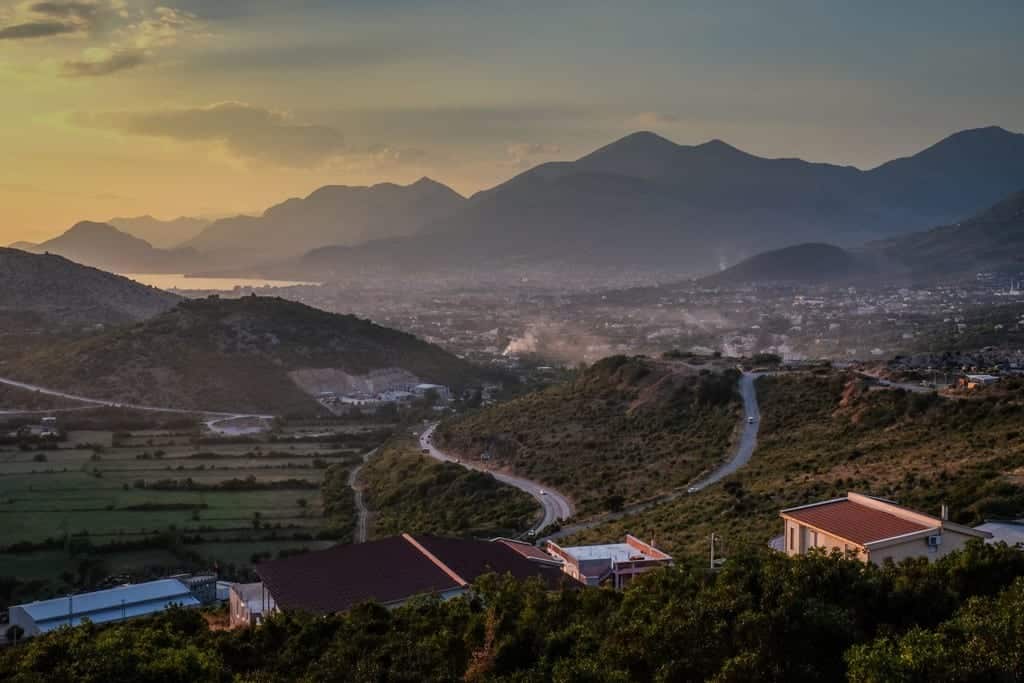 Montenegro after sunset: a mountainous backdrop with a city in the distance.