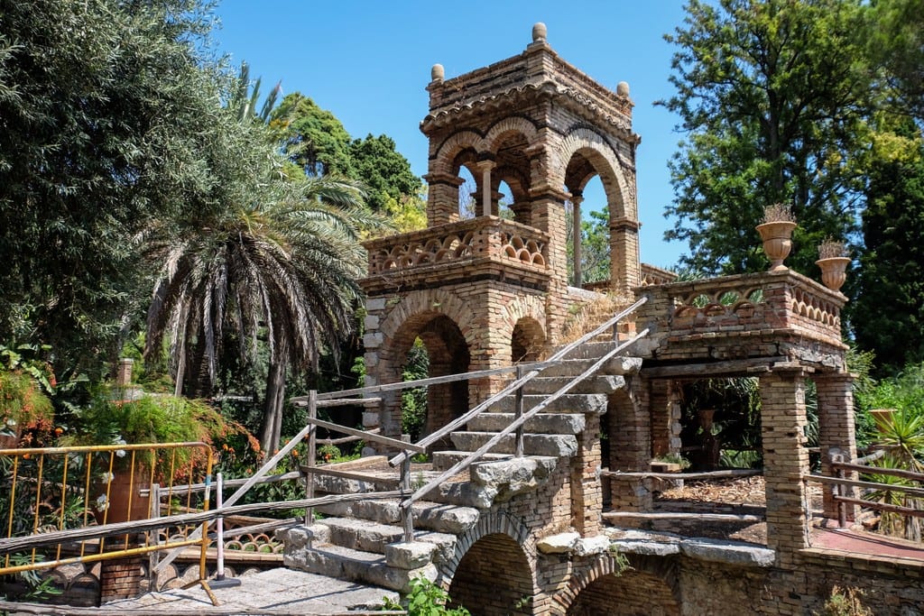 A stone church-like building set amid a botanical garden.