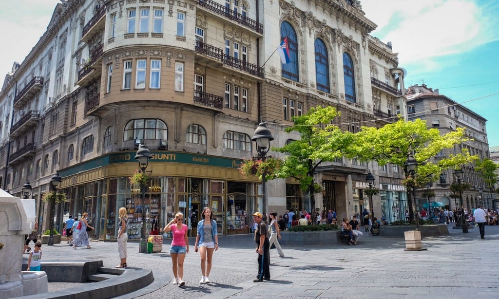 Two women walking on a city street in Belgrade.