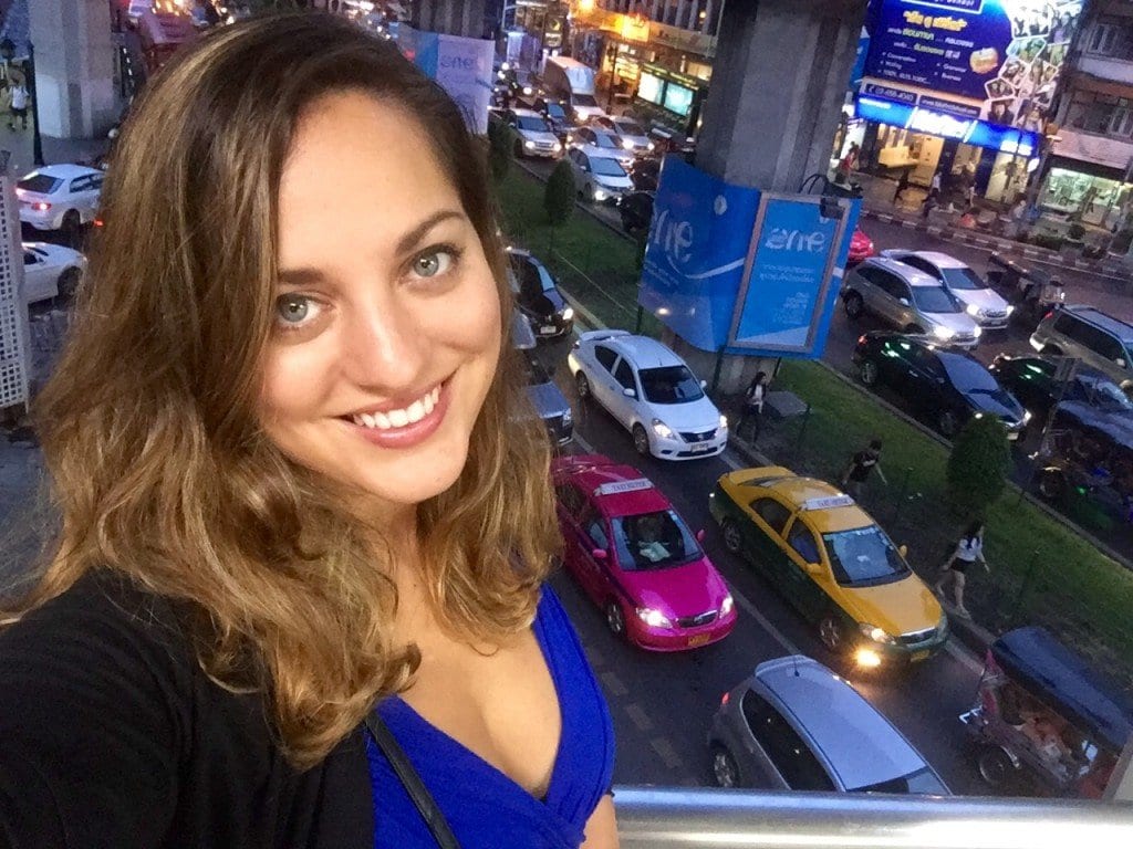 Kate stands in front of a line of cars in Siam Square, Bangkok.