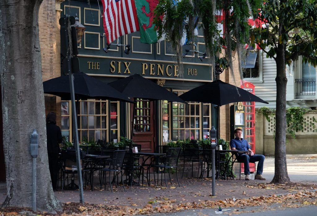 A man sitting outside an Irish pub called Six Pence in Savannah.