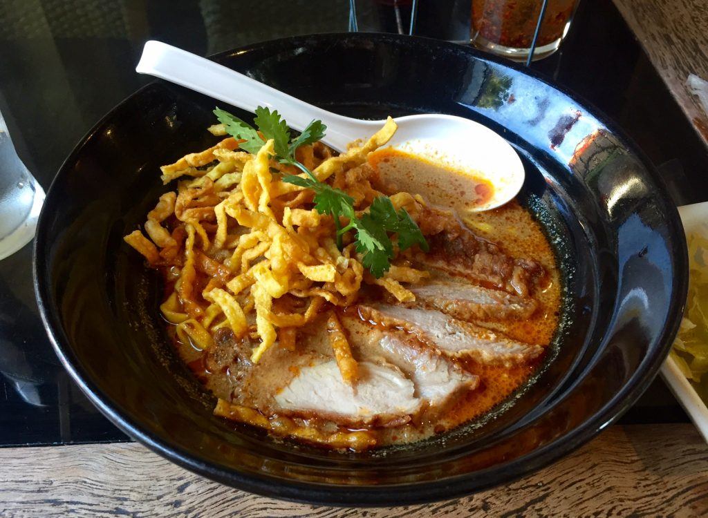 A bowl of Khao soi noodle soup topped with wontons in Chiang Mai.