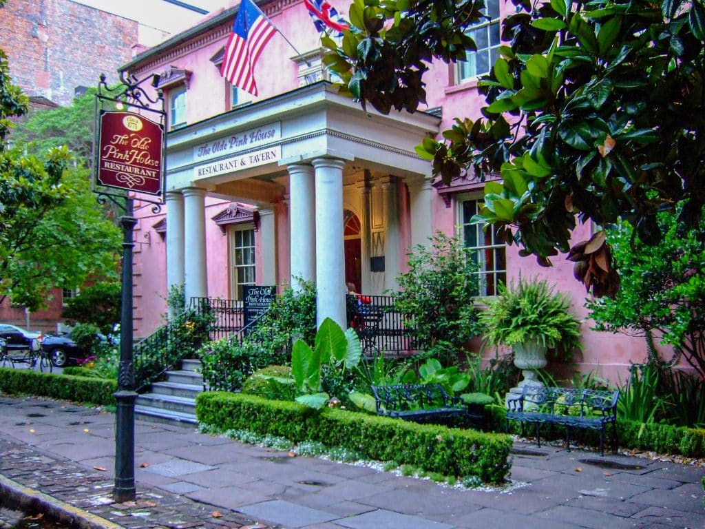 A big, grand pink house with Greek columns on each side.