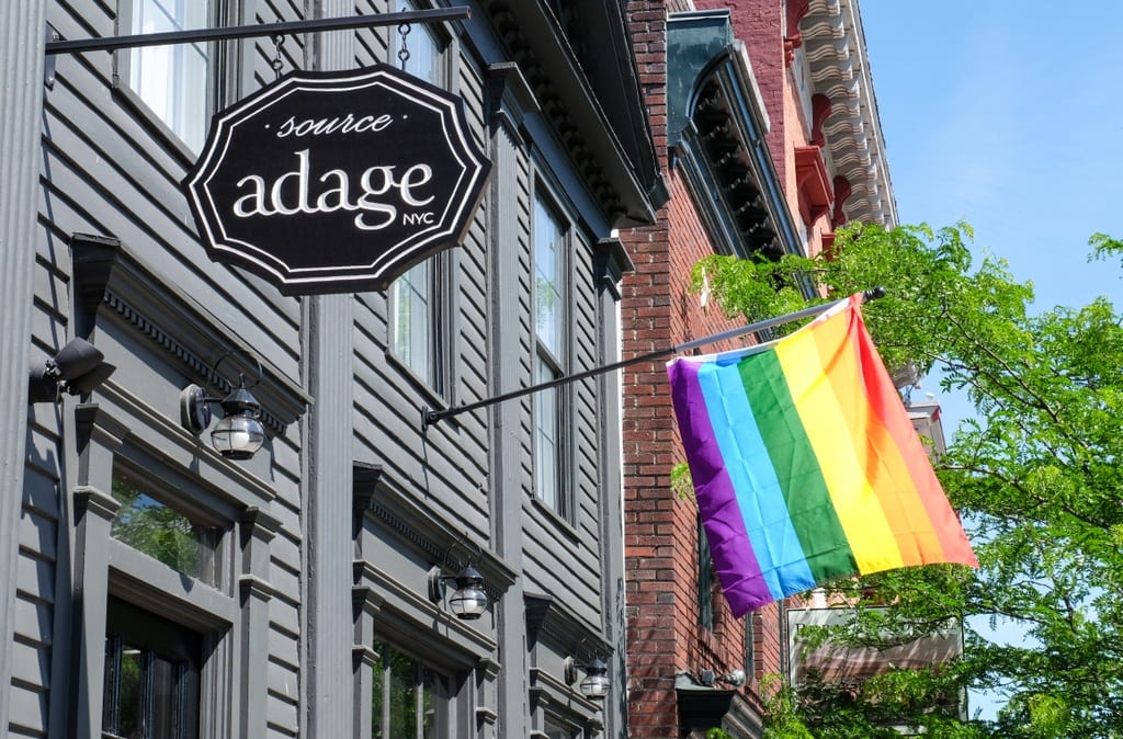 A store reading "adage NYC" next to a rainbow Pride flag.